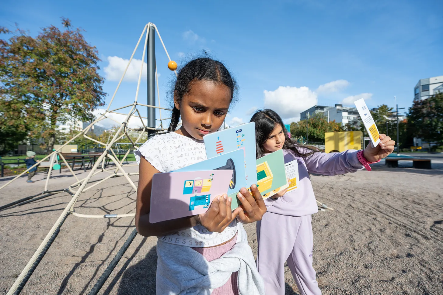 Children playing with activity cards at Ruoholahti Playground